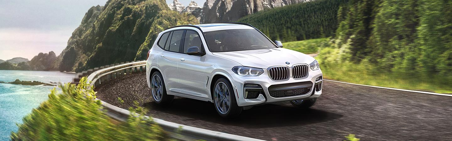 2021 BMW X5 driving on a road by water