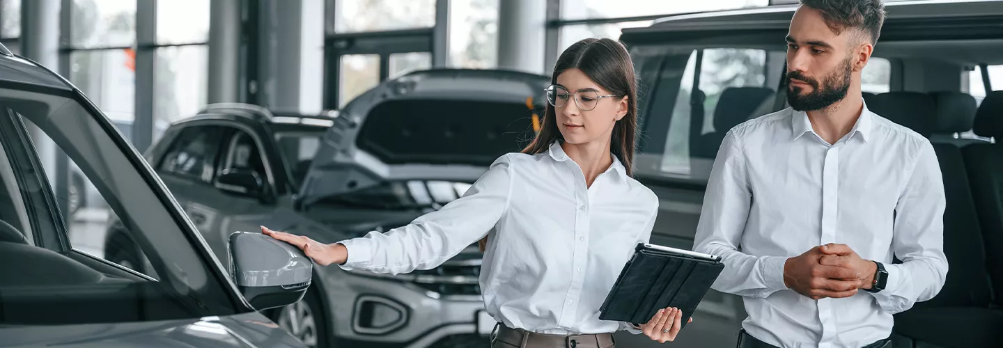Car saleswoman showing someone a new car
