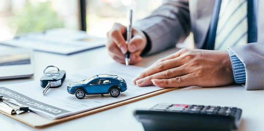 person at a desk signing for automobile in dealer keys on desk