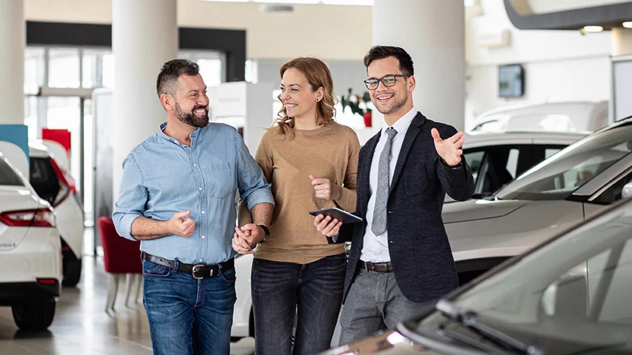 couple being introduced to new cars by a salesperson
