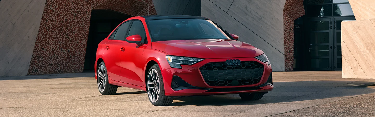 Front view of a parked red 2025 Audi A3 at a house