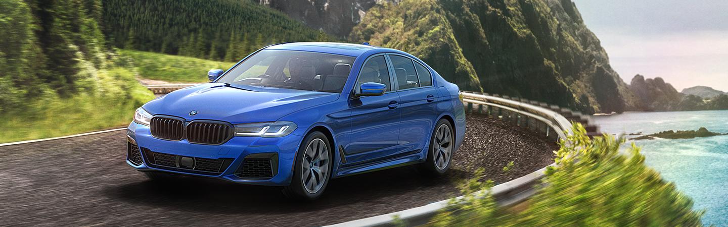 2021 BMW 5 Series driving by water