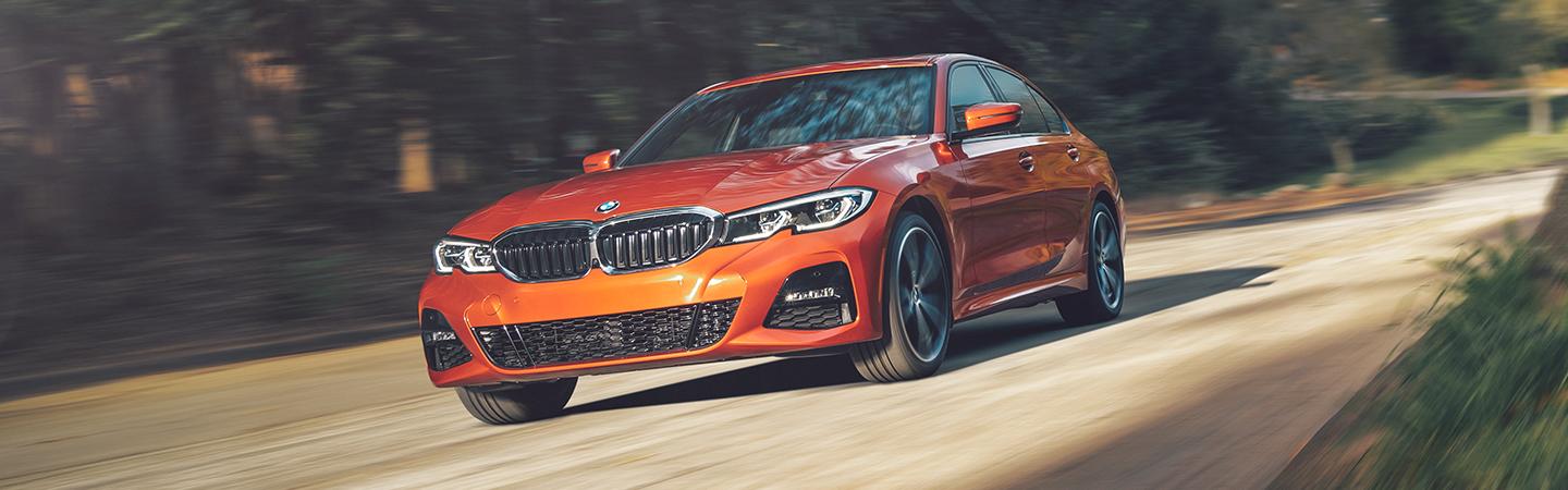 2021 BMW 5 Series driving in a road in the woods