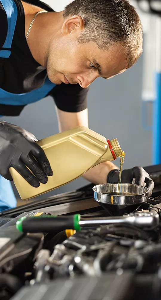 Service mechanic workin under the hood of a vehicle