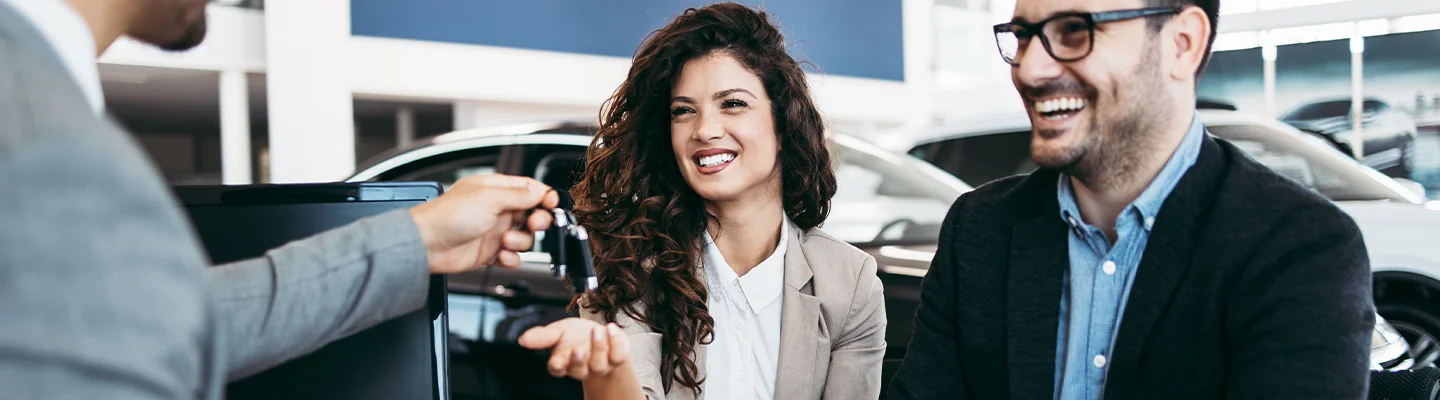 Sales perosn handing over car keys to customers for there new Used Exotic Vehicles for Sale in Naples, FL