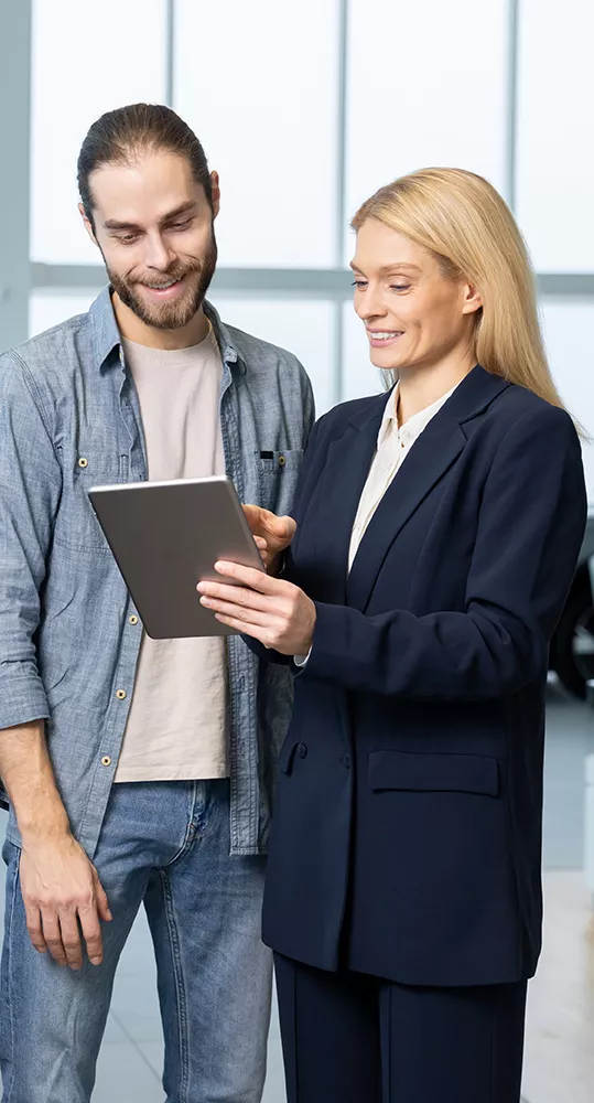 two people discussing car details using a pad computer in the showroom