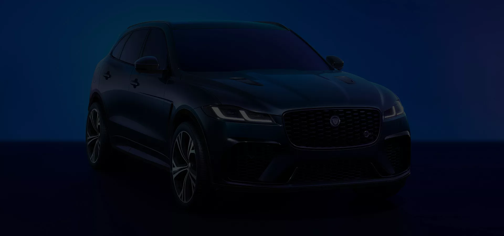 Front view of a Jaguar SUV in a dark setting