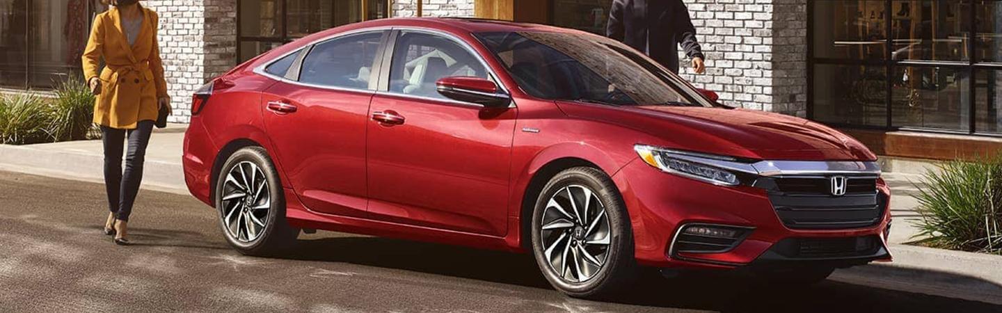 Red 2022 Honda Insight Hybrid parked with people walking to it