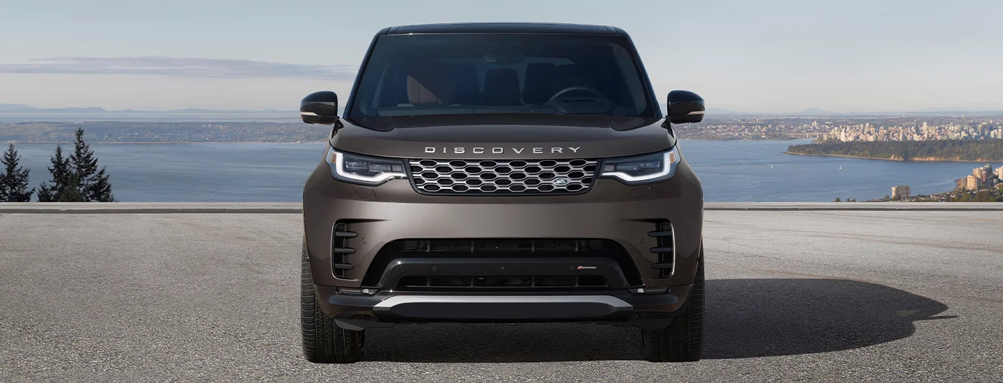 Front view of a parked 2025 Discovery by some water