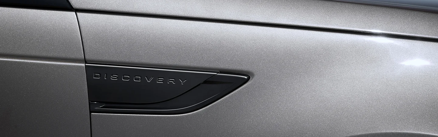 Close up of the Discovery logo on the SUV