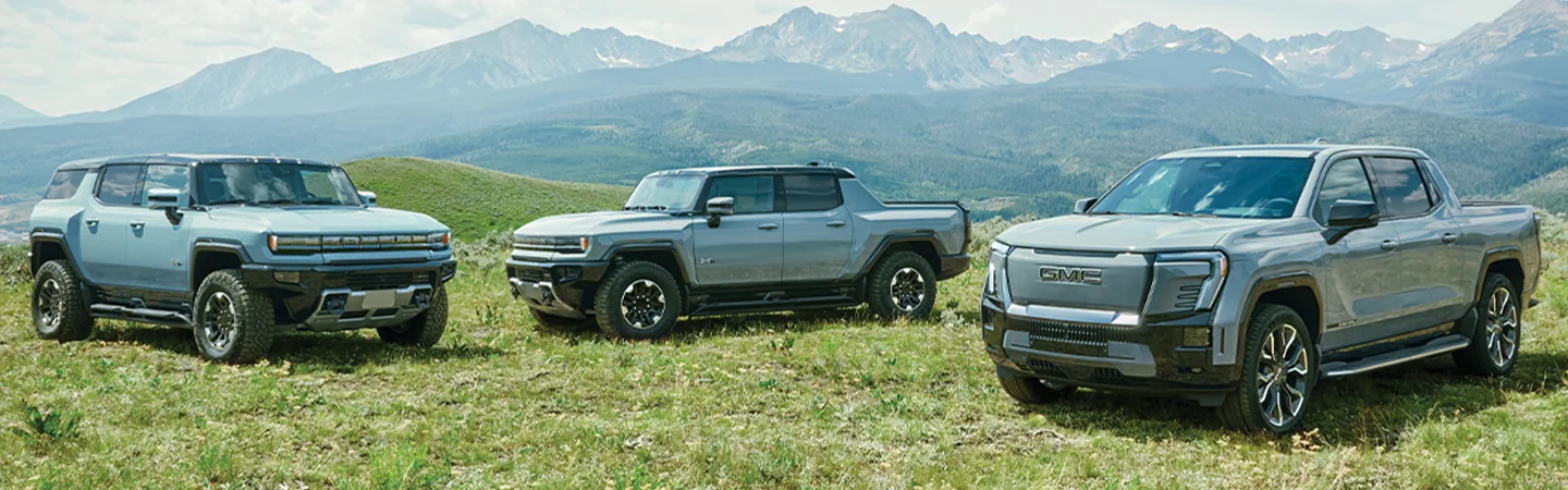 3 2025 GMC HUMMER EV SUV parked on mountains
