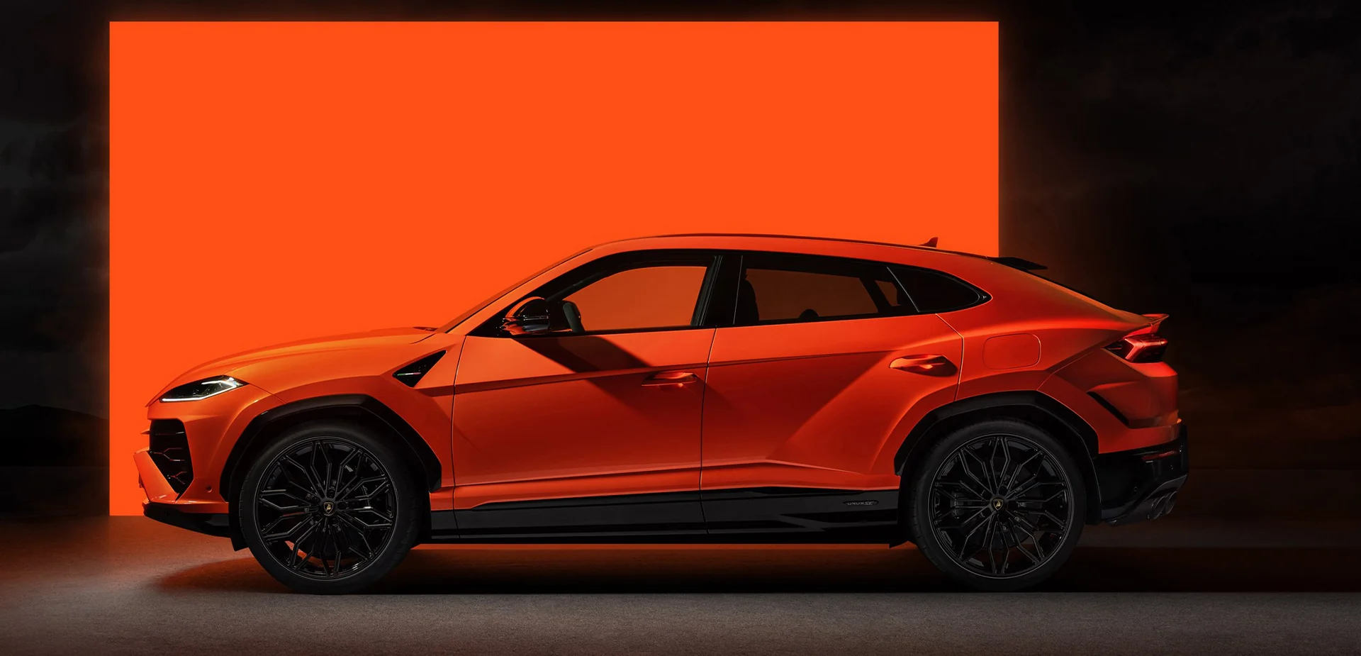 Side view of a parked orange 2026 Lamborghini Urus