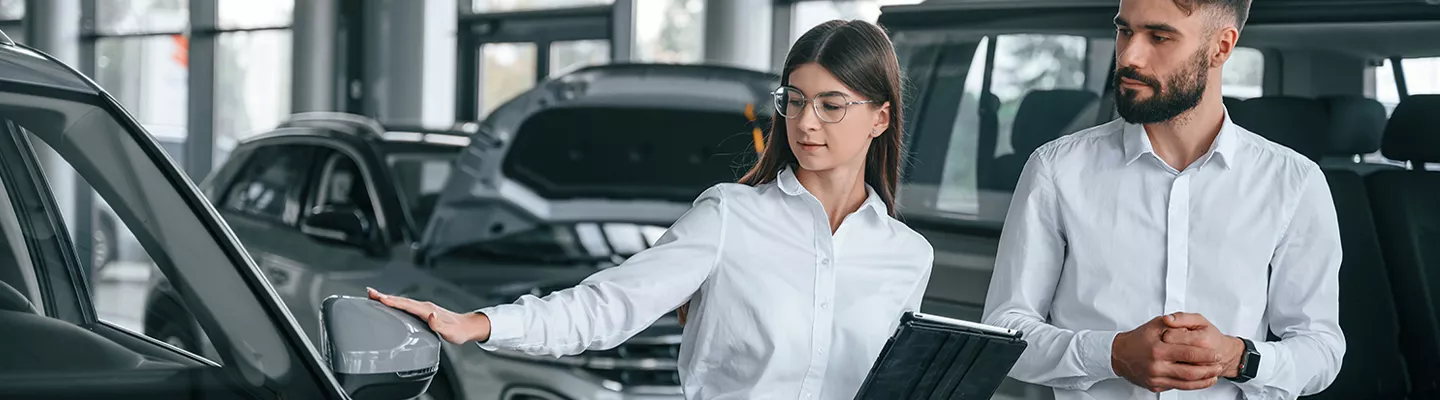 salesman and saleswoman looking over the vehicles