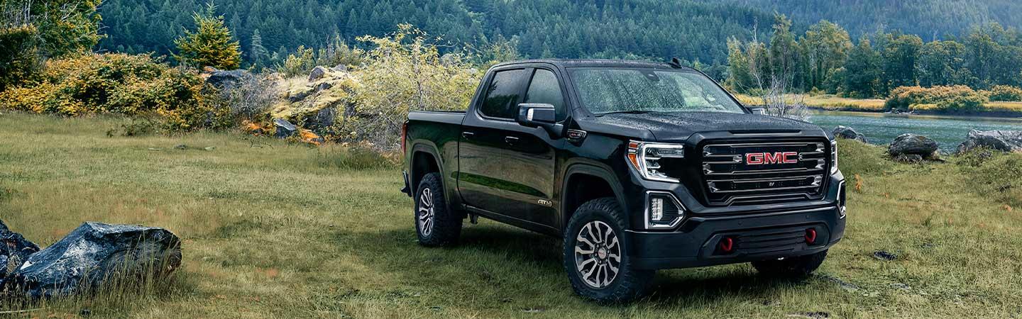 2022 GMC Sierra 1500 parked in field by mountains and lake