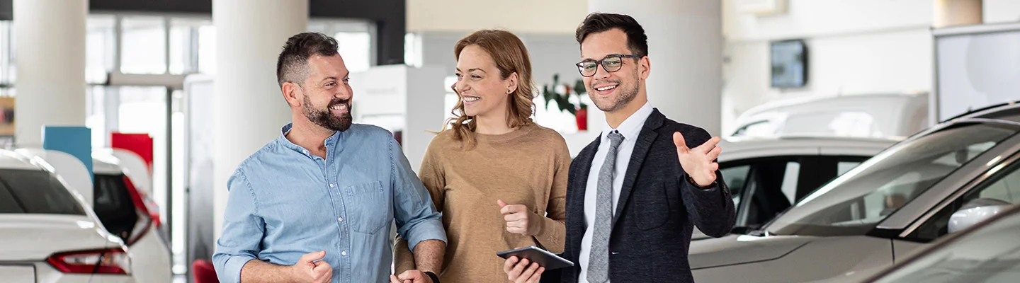 Sales person helping customers shop for new cars
