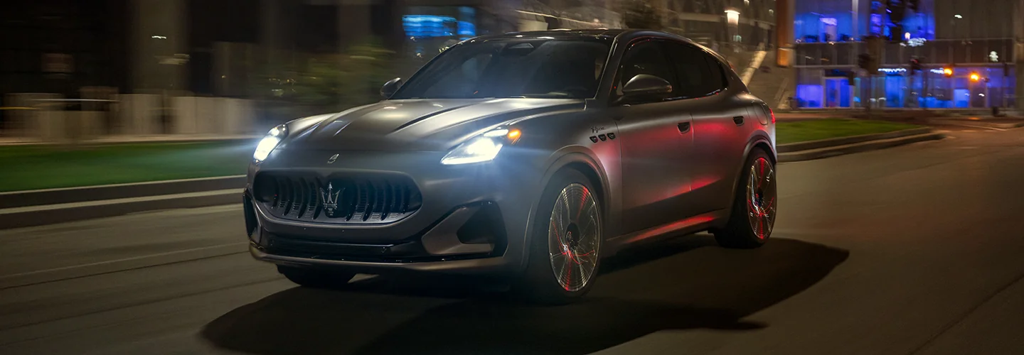 Gray Maserati driving though the city