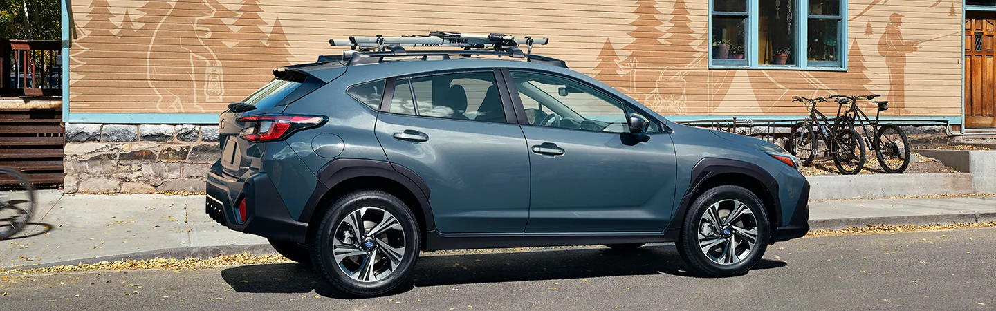 Side view of a parked blue 2025 Subaru Crosstrek next to a camping building in Waco, TX