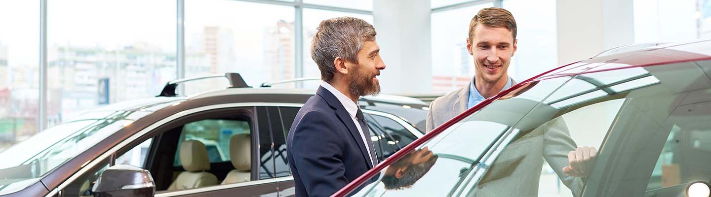 men near new car smiling