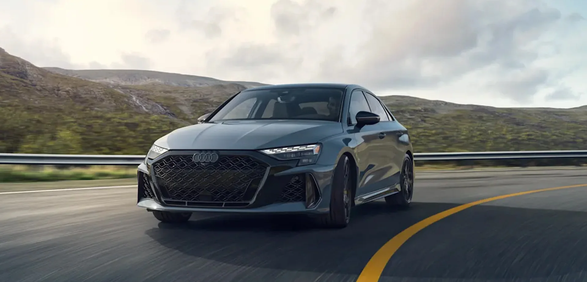 Front view of a gray 2026 Audi RS 3 driving on the road