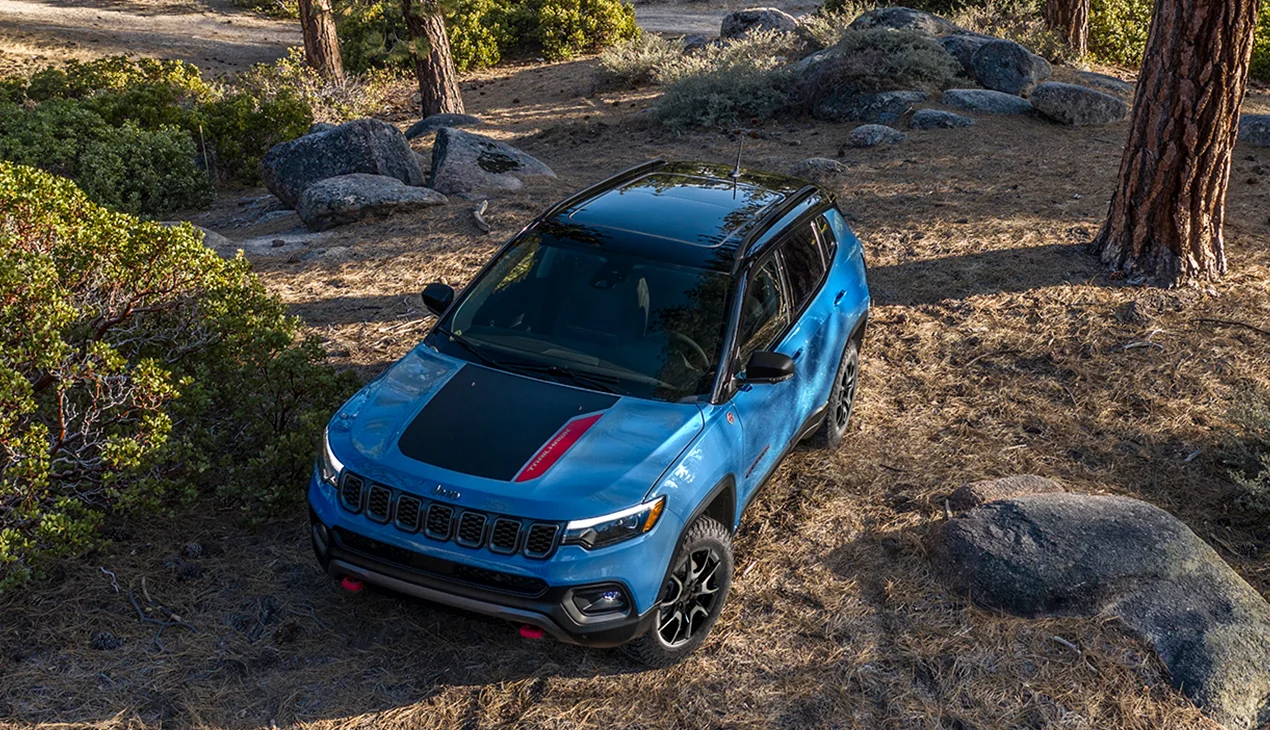 Front top view of a blue Jeep Cherokee parked in the woods