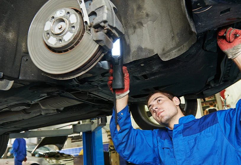 Service tech looking at brakes on a car
