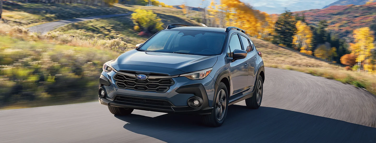 Front view of a gray 2025 Subaru Crosstrek driving on a country road in Nederland, TX.