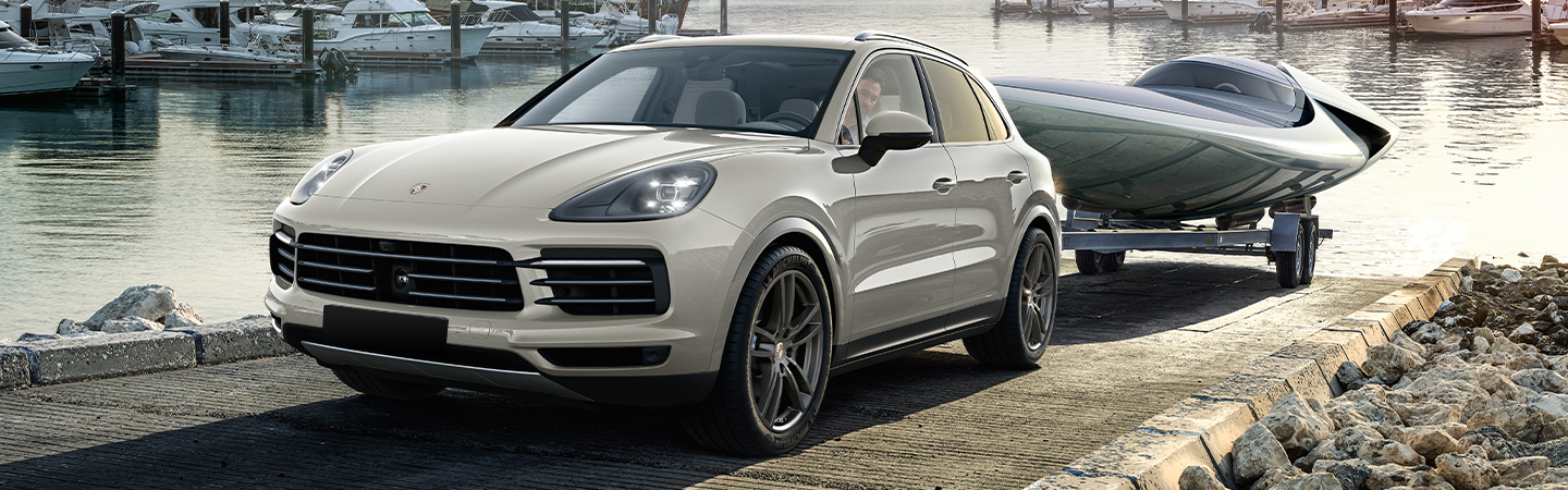 White 2021 Porsche Cayenne towing a boat