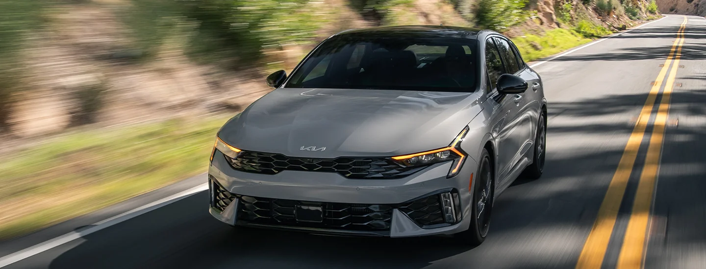 Front view of a 2025 Kia K5 driving down the road
