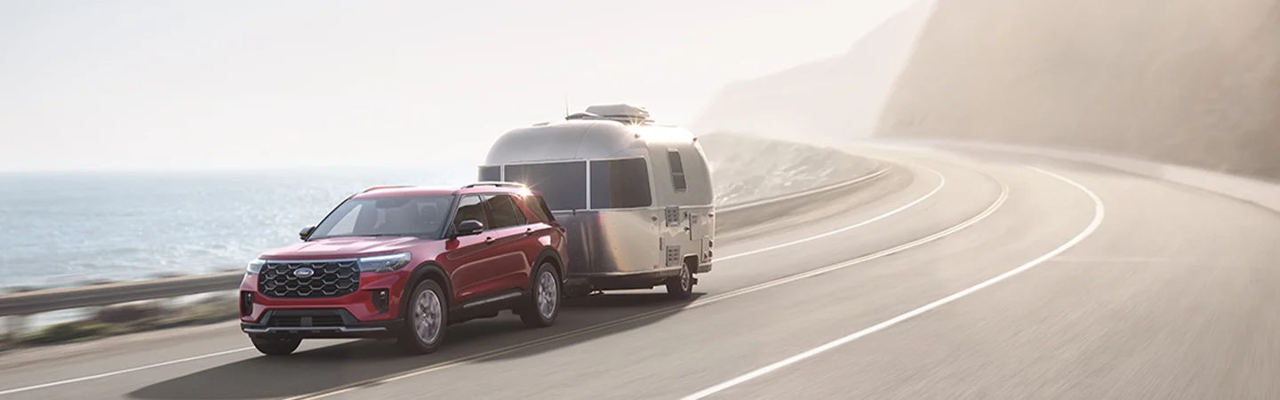 red 2025 Ford Explorer towing camper