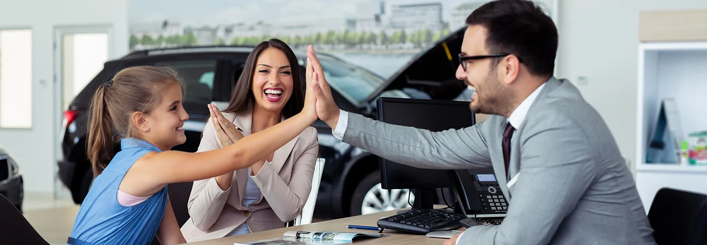 A young girl receives a high five from a man and woman, capturing a moment of celebration.