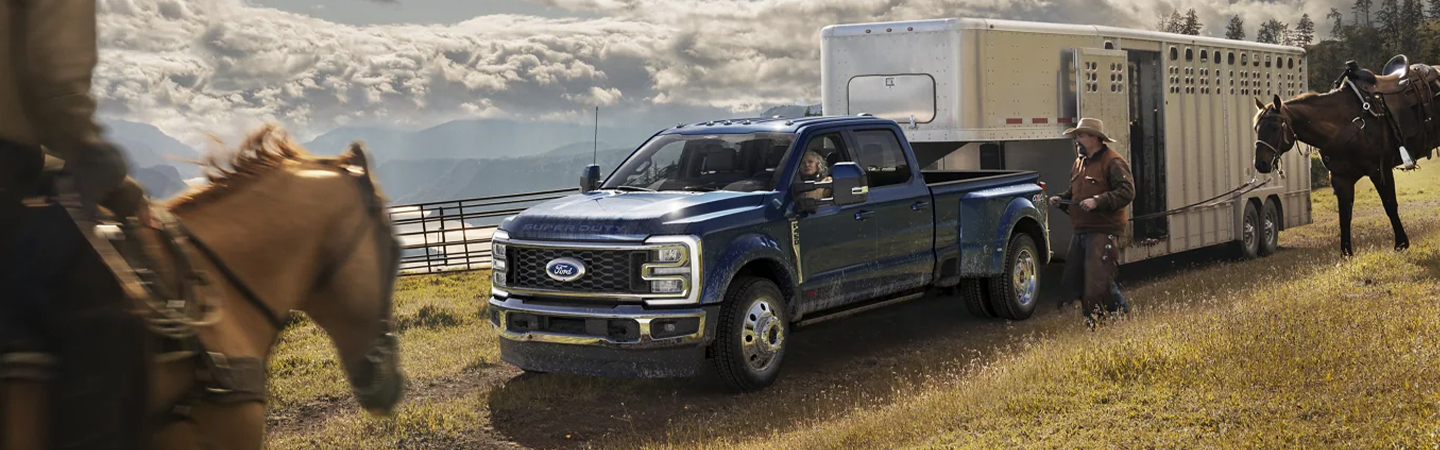 2023 Ford Super Duty hauling horse trailer with a guy riding a horse towards the truck
