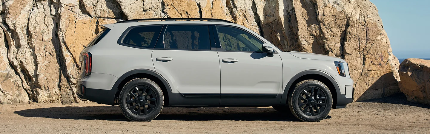 Side view of a 2025 Kia Telluride parked by some rocks