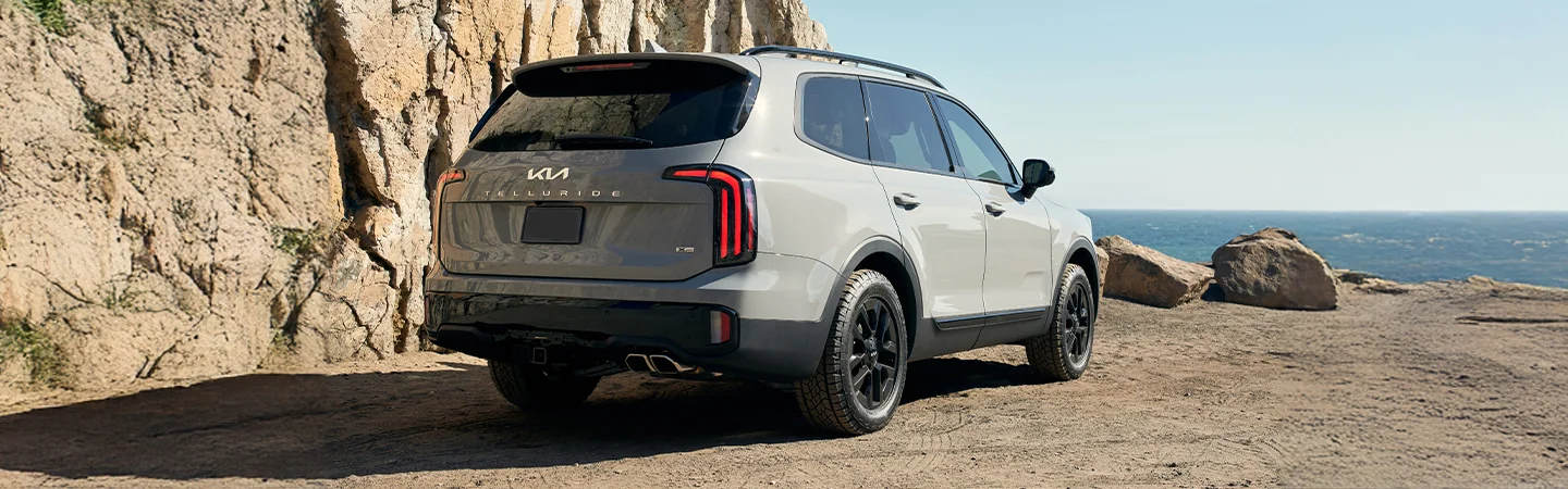 Back side view of a2025 Kia Telluride parked by rocks and the ocean