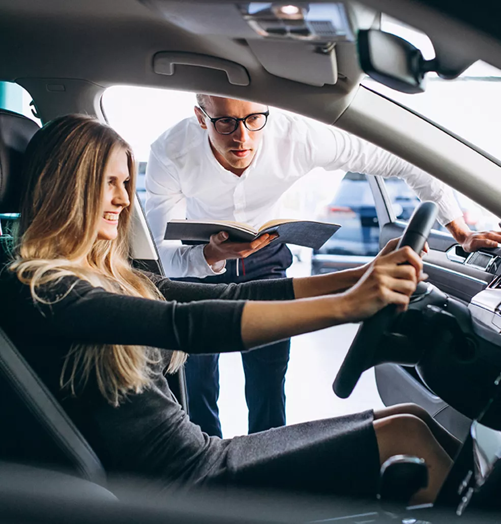 Woman sitting in a new vechile at a car dealership