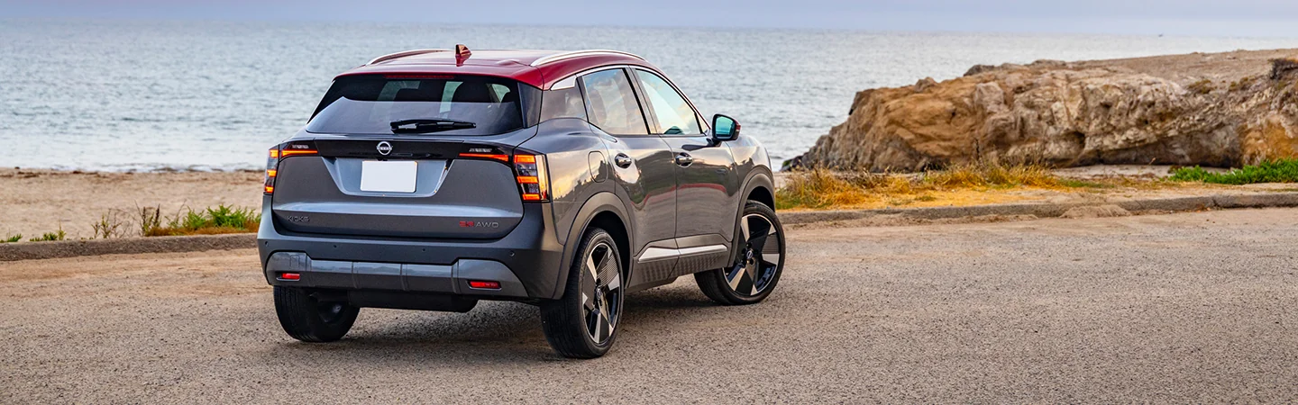 Back view of a parked gray 2025 Nissan Kicks by the water