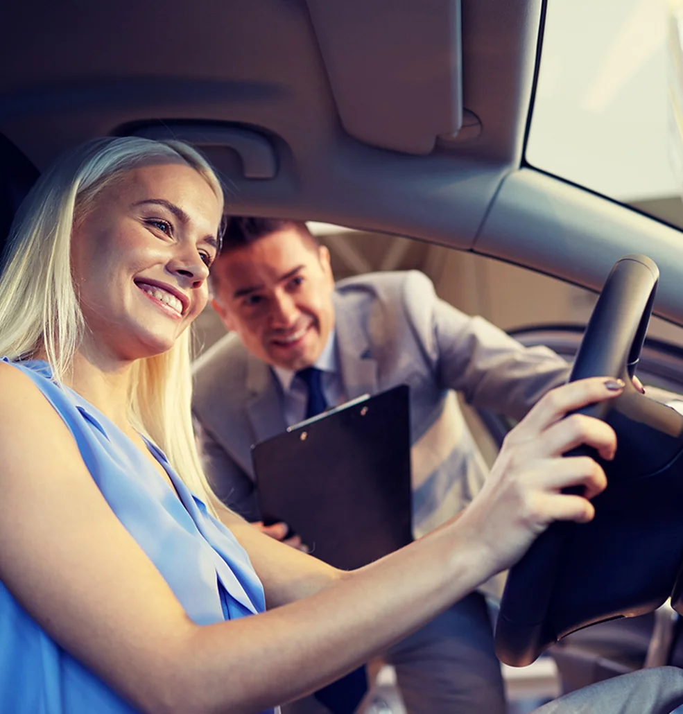 Sales person showing a customer the inside of the new car