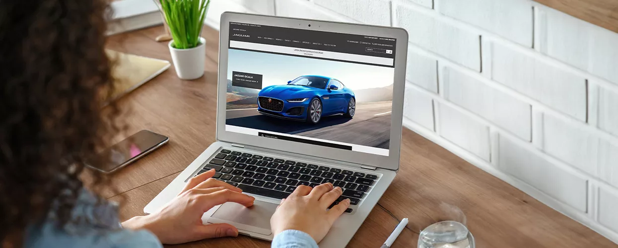 Woman using her laptop to browse the Jaguar Ocala website