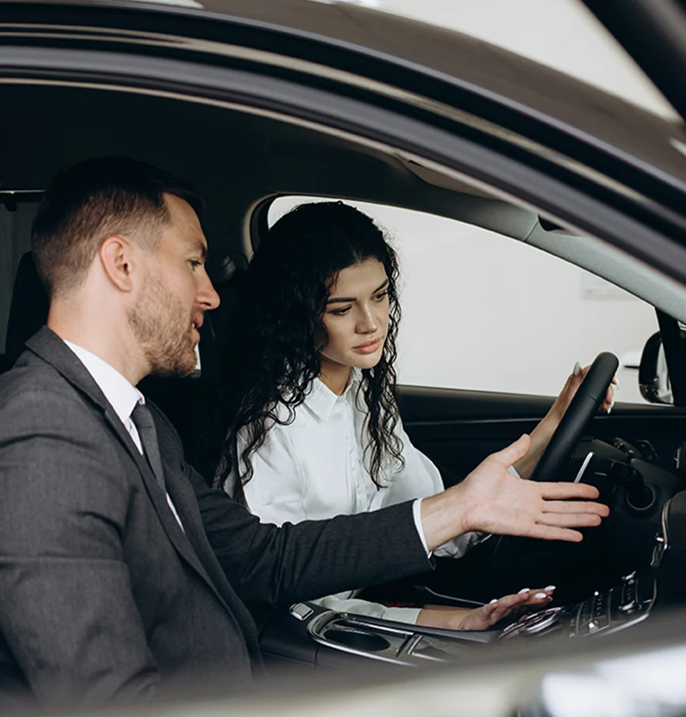 A man and woman talking to each other inside a car.