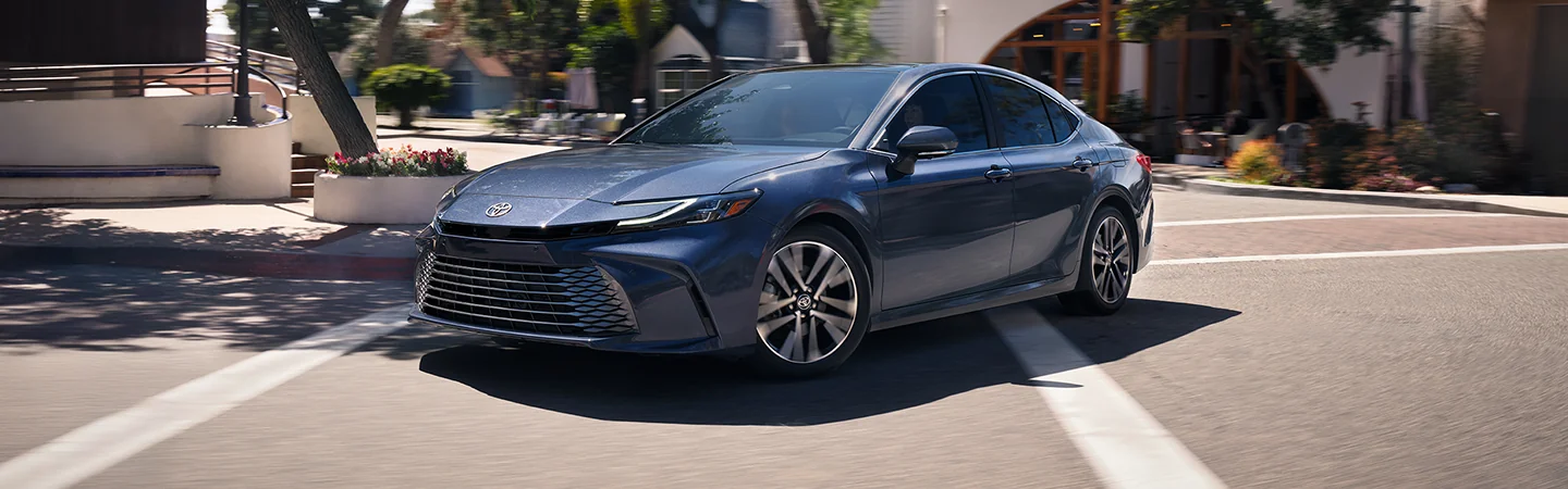 Side view fo a blue 2026 Toyota Camry making a turn in the city