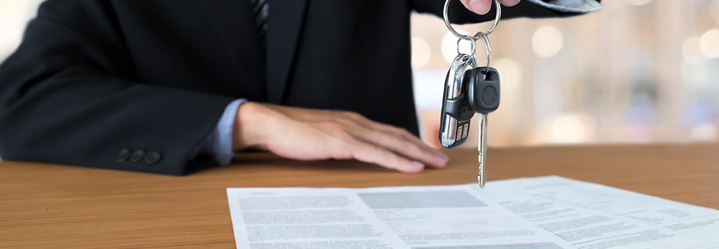 Sales person hading over new car keys