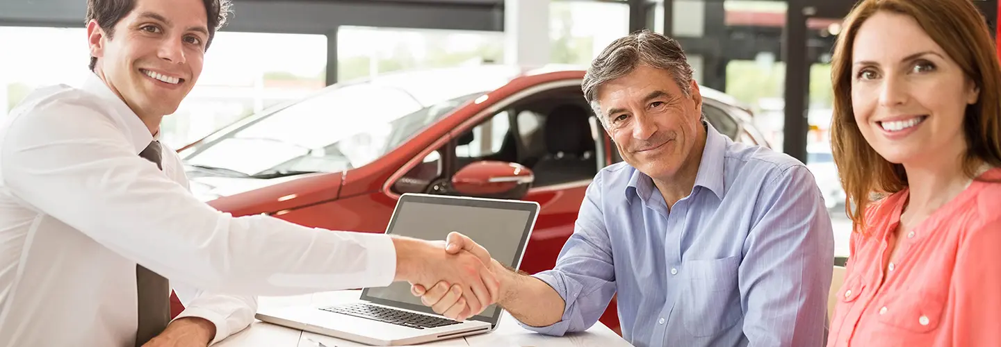 people shaking hands for a new car at our dealership showroom