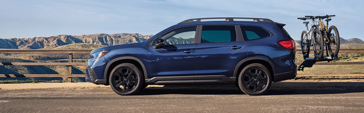 2025 Subaru Ascent parked near mountains with bikes on the back