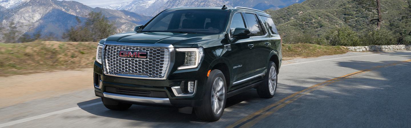 Black 2022 GMC Yukon driving on the road