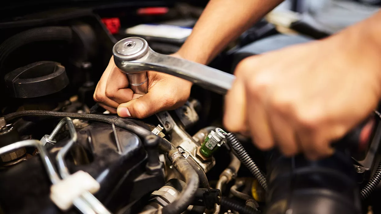 Mechanic working on a car under the hood