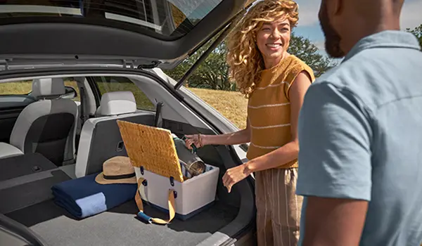 folks getting gear out of back of new car