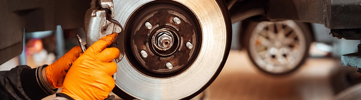 auto mechanic working on brakes