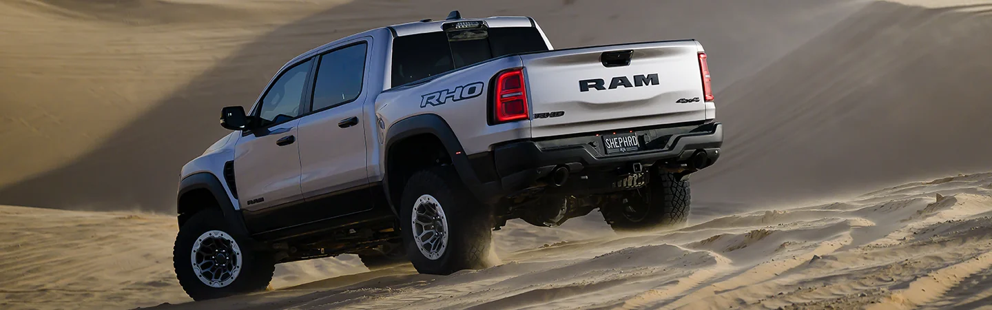 white 2025 RAM 1500 driving in desert