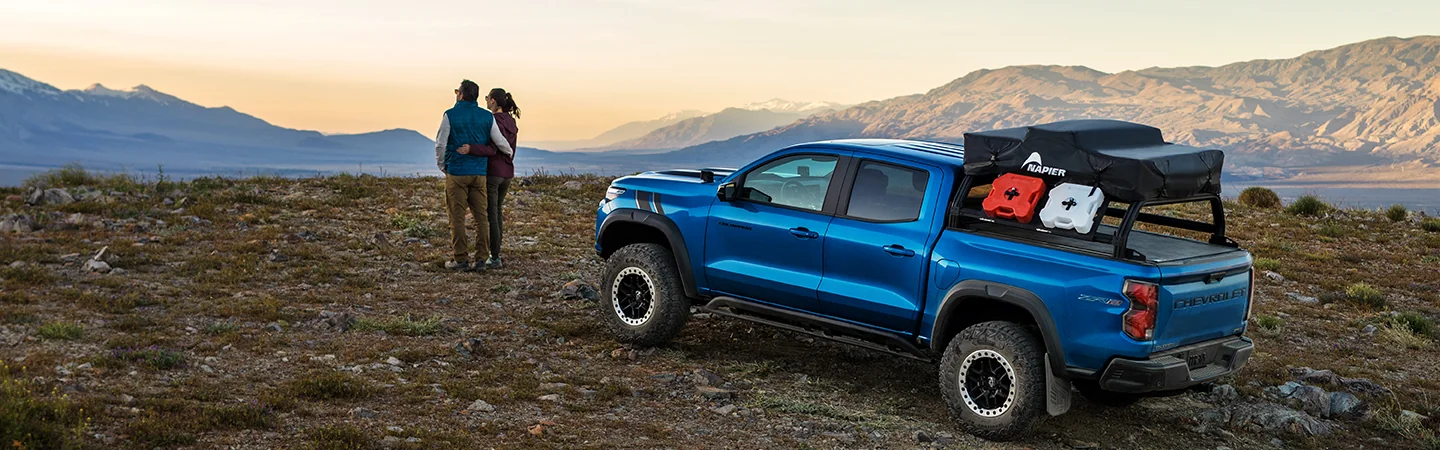 A parked blue 2025 Chevrolet Colorado with a family looking out at mountains