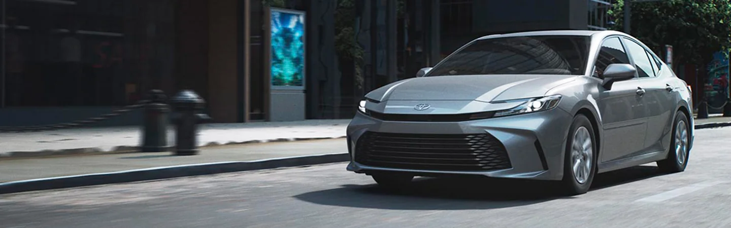 2025 Toyota Camry vs Toyota Corolla gray color car stand on city