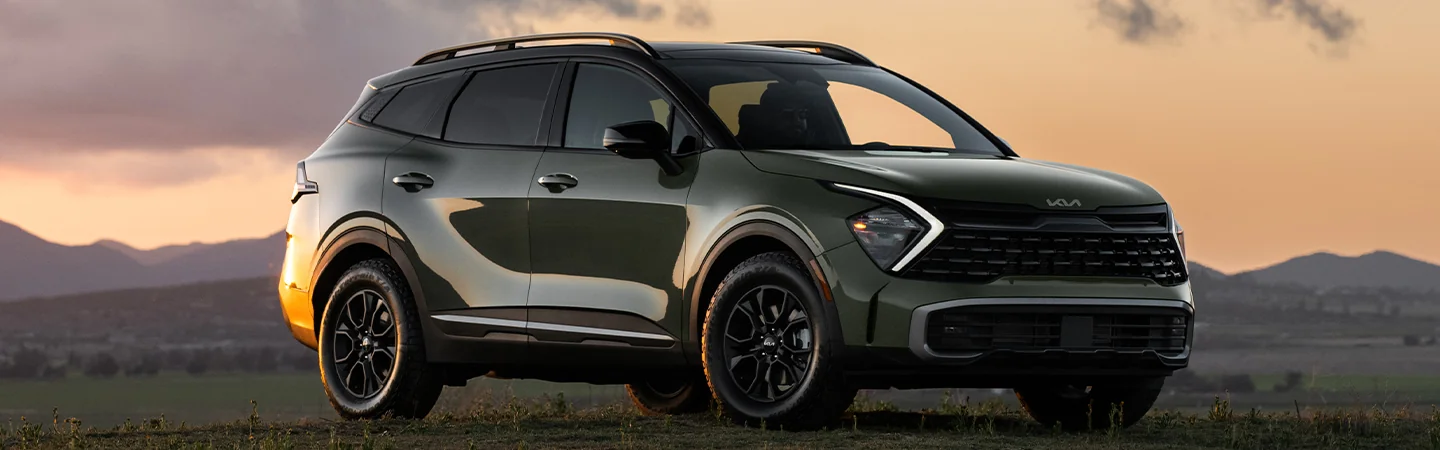 parked green 2025 Kia Sportage in some grass